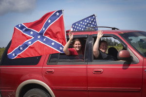 Rachel (left) and Lana Rounsavall of Loxahatchee wave as they participate in an "American & Southern Flag Rally"  in western Palm Beach County Saturday, July 11, 2015. "We are doing this for southern pride, not hate or racism," said Lana. "The flag is something that belongs to us. They don't have the right to take it away." (Bruce R. Bennett / The Palm Beach Post)