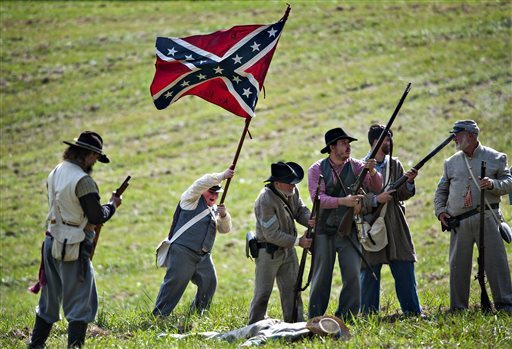 In this Sept. 12, 2015, photo Daniel Bowman, 12, waves a Confederate flag as he stand with his regiment during the Hart County Civil War Days historical re-enactment of the Battle of Munfordville in Munfordville, Ky. (Miranda Pederson/Daily News via AP) MANDATORY CREDIT MIRANDA PEDERSON — AP