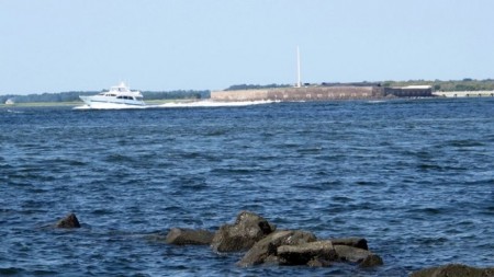 A pleasure boat motors past Fort Sumter in this Friday, Sept. 9, 2016, photograph taken from the beach on Sullivans Island, S.C. (AP Photo/Bruce Smith)