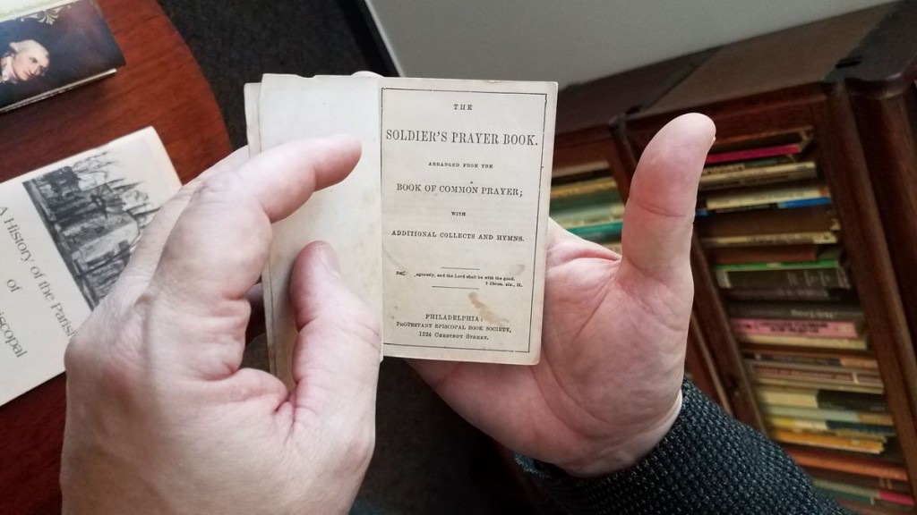 The Rev. Robert Alves shows the inside of The Soldier's Prayer Book, which was used by Union soldiers during the Civil War.