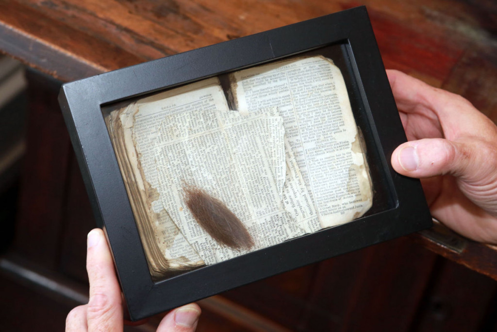 Civil War scholar Jack Davis examines a Bible and lock of hair that belonged to John Taylor Radford, brother of Nannie Radford Wharton. John Radford, a Confederate soldier was killed in 1864 in Ciderville. A fellow soldier returned the items to the Wharton family.