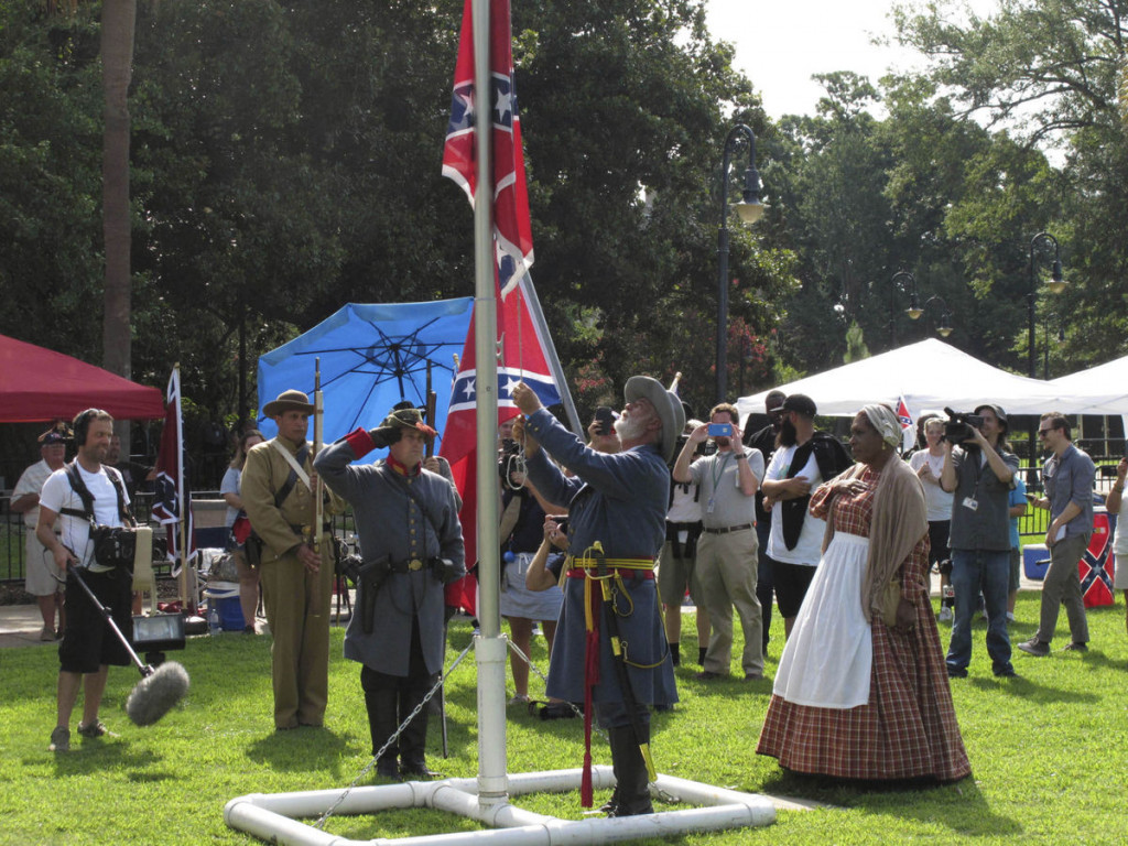 Arlene Barnum, right, watches as Braxton Spivey raises a Confederate flag on the grounds of the South Carolina Statehouse on July 10, 2017, in Columbia. The South Carolina Secessionist Party sponsored the event to commemorate the day the flag was removed from the front lawn of the state capitol. The Secessionist Party says it will raise the flag every July 10th so a year will never go by without the Confederate flag flying. (AP Photo/Jeffrey Collins)